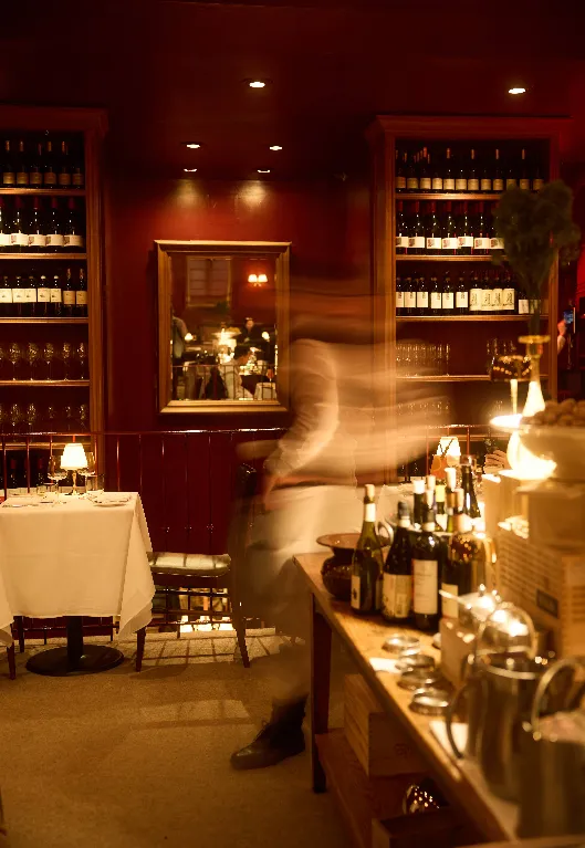 Babbo dining room with wine shelves and white tablecloths